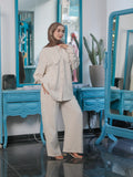 COPRO look in beige, showing a cape-collar button-front shirt with long sleeves and matching wide-leg trousers.