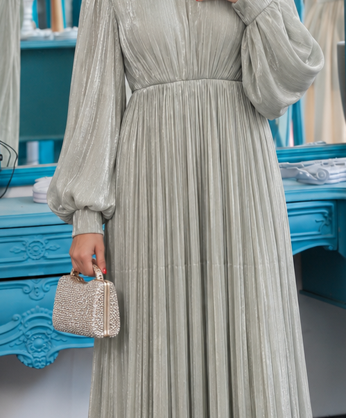 Close-up of Aurelia Pleated Gown showing sage gown gathered bodice, embellished waist and pleated skirt, cropped from the original product photo.